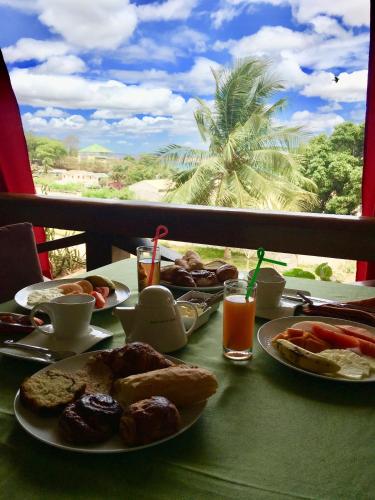 a table with plates of food and drinks on it at Hotel de la Poste in Diego Suarez