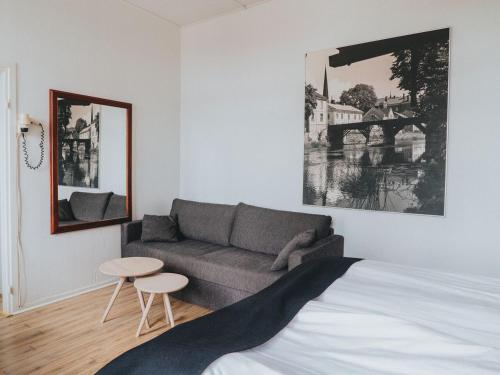 - une chambre avec un lit, un canapé et une table dans l'établissement Arboga Stadshotell, à Arboga
