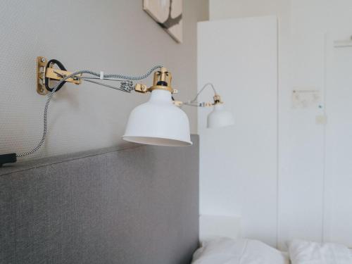 a lamp on the wall of a bedroom at Arboga Stadshotell in Arboga