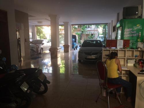 a woman sitting at a counter in a restaurant at Bắc Nam Hotel in Da Nang