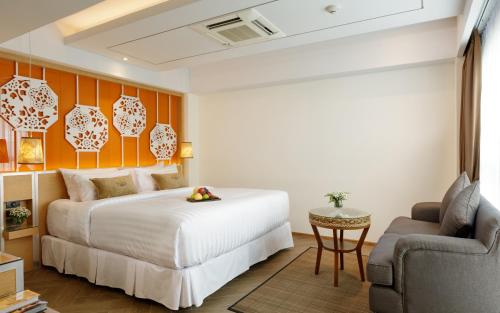 une chambre d'hôtel avec un lit et une chaise dans l'établissement 9 SUITE Luxury Boutique Hotel, à Chiang Mai