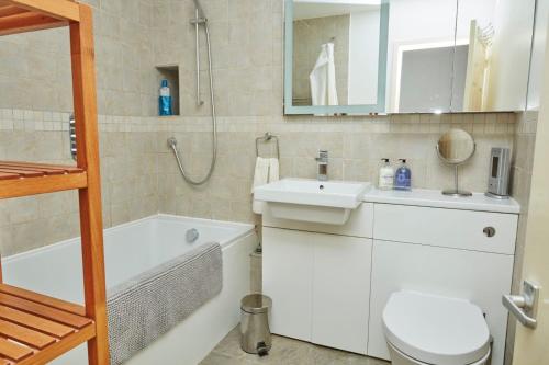 een badkamer met een wastafel, een bad en een toilet bij Brecknock Road House in Londen