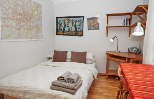 een slaapkamer met een bed met handdoeken erop bij Brecknock Road House in Londen