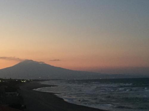 a beach at sunset with a mountain in the background at Paradiso fronte Mare in Agnone Bagni