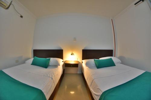two beds in a room with green and white at Hotel Montserrat Plaza in Monterrey
