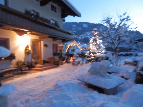 a building with a christmas tree in the snow at Reiserhof in Zell am Ziller