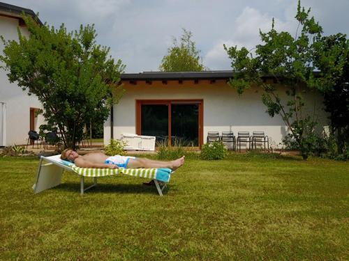 a man laying on a chair in the grass at Aganis in Casarsa della Delizia