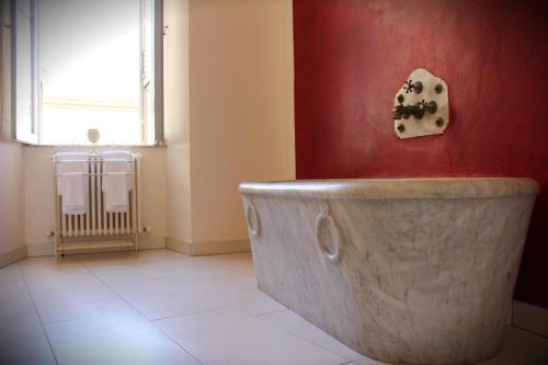a bath tub in a bathroom with a window and a radiator at B&B Antica Biblioteca in Fermo