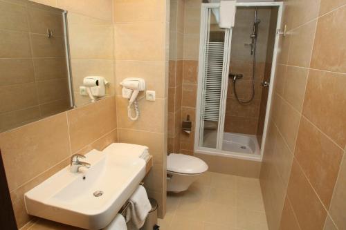 a bathroom with a sink and a toilet and a shower at Hotel Tęczowy Młyn in Kielce
