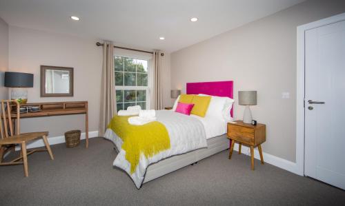 a bedroom with a bed and a desk and a window at Darlington Arms in Redhill
