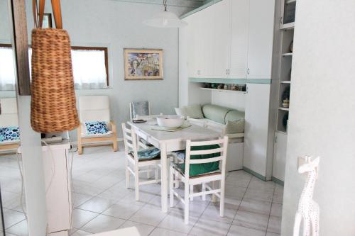 eine Küche und ein Esszimmer mit einem Tisch und Stühlen in der Unterkunft Lagomare Puccini in Torre del Lago Puccini