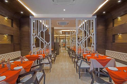 a dining room with orange tables and chairs at Kalinga Hotel in Jodhpur