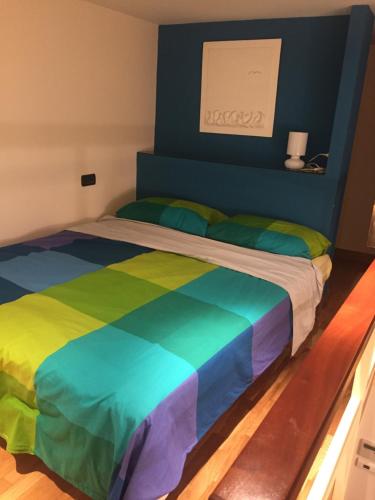 ナポリにあるAppartamentino 116 Via Chiaiaのベッド1台(虹色の掛け布団付)