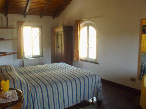 um quarto com uma cama e duas janelas em casa al colle em Lucca