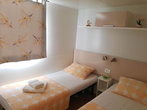 Habitación con 2 camas y toallas. en Mobile Homes Seashell Jezera, en Jezera