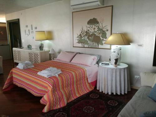 パレルモにあるLa Terrazza di Jennyのベッドルーム1室(ベッド1台、ランプ付きテーブル付)