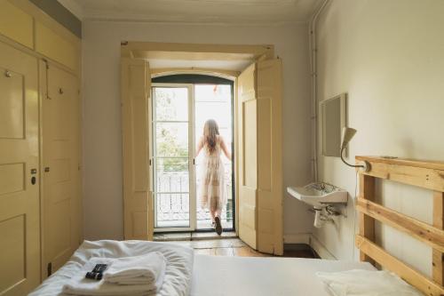 een vrouw die een slaapkamerdeur uitloopt bij WOT New Lisbon in Lissabon