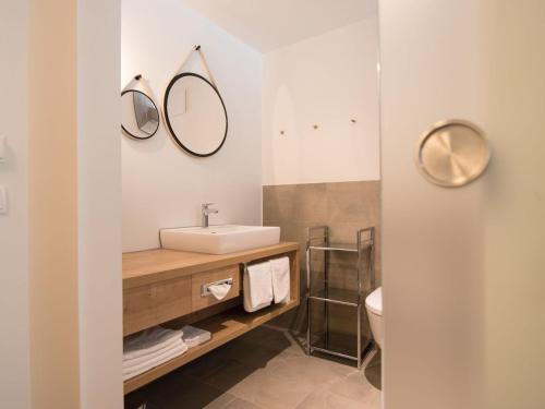 a bathroom with a sink and two mirrors on the wall at Valavier Aktivresort in Brand