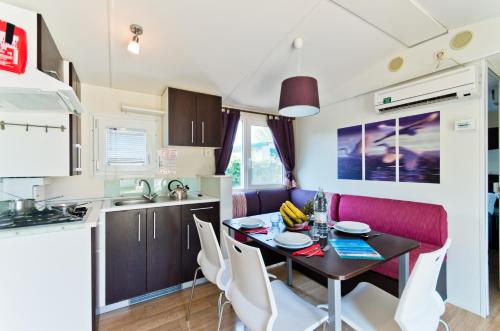 a kitchen and dining room with a table and chairs at Campeggio del Garda in Peschiera del Garda