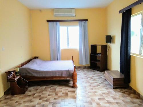 Hotel Chez Fanny في Kpalimé: غرفة نوم بسرير ونافذة