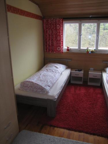 1 dormitorio pequeño con 1 cama y 2 ventanas en Ferienwohnung Familie Doris, en Treuchtlingen