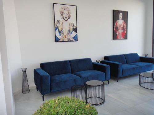 a living room with two blue couches and tables at Asilah 32 in Asilah