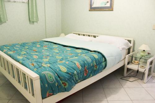 - une chambre avec un lit blanc et une couverture bleue dans l'établissement Lagomare Puccini, à Torre del Lago Puccini