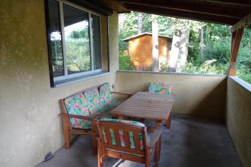 a porch with a wooden table and two chairs at Ferienhaus Julia in Stechlin