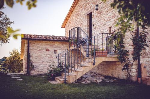a stone house with a staircase on the side of it at Agriturismo Casal San Sergio in Fossombrone