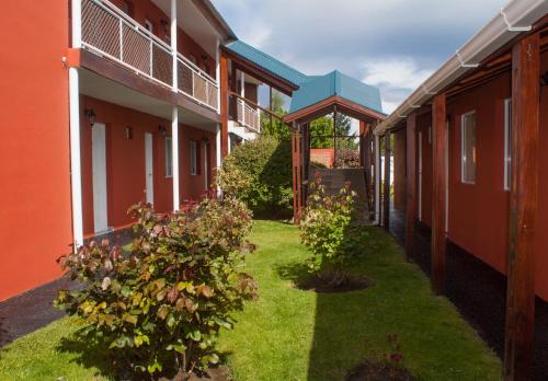 a courtyard of an apartment building with grass and plants at Hosteria Patagonia in El Calafate