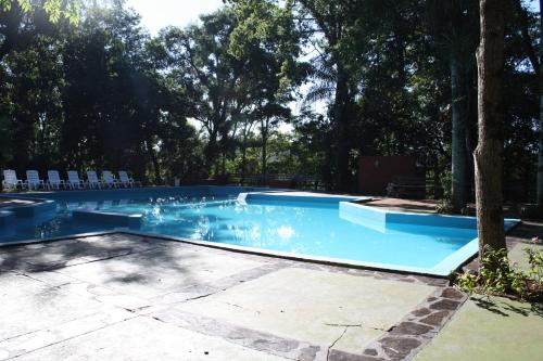 a large swimming pool with chairs and trees at Complejo Paranay in Puerto Paranay