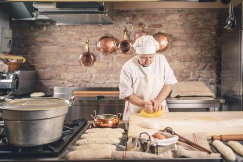 a chef standing in a kitchen preparing food at Agriturismo Casal San Sergio in Fossombrone