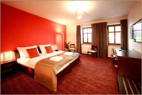 ズノイモにあるHotel Lahoferの赤い壁の大型ベッドが備わるホテルルームです。