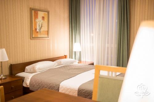 a hotel room with a bed and a window at L'ascada Hotel in Śrem