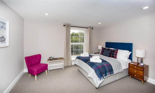 a bedroom with a bed and a chair and a window at Darlington Arms in Redhill