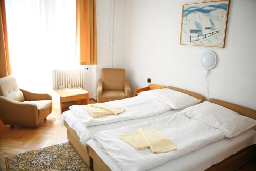 1 Schlafzimmer mit 2 Betten und einem Stuhl in der Unterkunft Hotel Bara Gellért in Budapest
