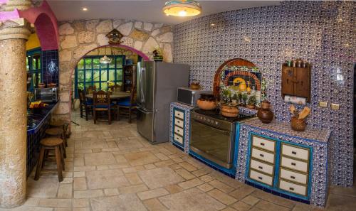 a kitchen with a stove and refrigerator in a room at Hacienda Boutique B&B and Spa Solo Adultos in Cozumel