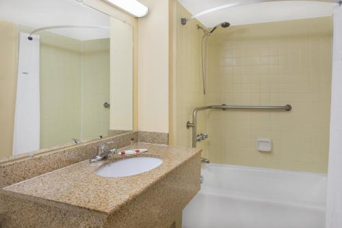 a bathroom with a sink and a shower at Days Inn by Wyndham Mt Pleasant-Charleston-Patriots Point in Charleston
