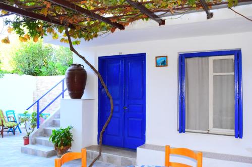 a blue door on a white house with two chairs at Stathis in Rhodes Town