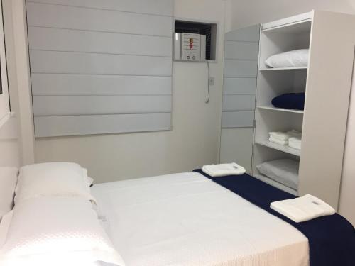 Habitación blanca con 2 camas y toallas en los estantes en Maayan 1307 Parque Olímpico, en Río de Janeiro