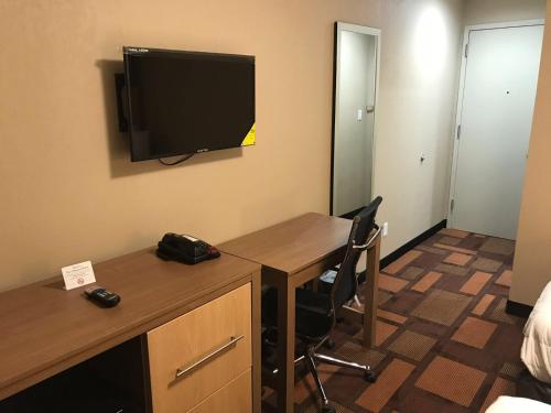 a room with a desk and a television on the wall at Days Inn by Wyndham Brooklyn Borough Park in Brooklyn