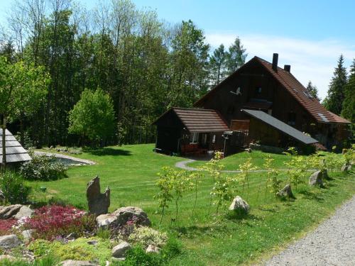 a barn with a garden in front of it at Penzion Na Habeši in Kašperské Hory