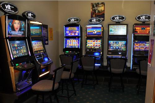 a bunch of slot machines in a room with chairs at El Lobo Motel in Cold Lake