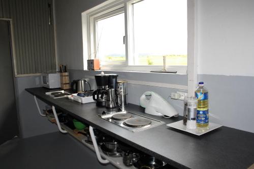 a kitchen with a counter with a coffee maker on it at Kaldbakur Guesthouse in Heimaland
