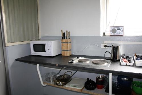 a kitchen with a microwave and a coffee maker at Kaldbakur Guesthouse in Heimaland