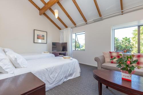 a bedroom with a bed and a couch and a table at Anzac Court Motel in Auckland