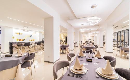 uma sala de jantar com mesas e cadeiras e um restaurante em Laki Hotel & Spa em Ohrid