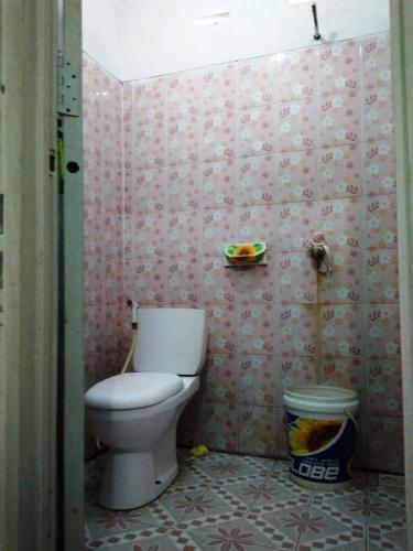 a bathroom with a toilet in a pink wall at Harapan Solata Homestay Syariah in Kepulauan Seribu