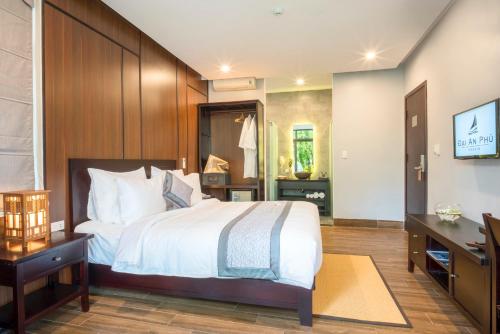 a hotel room with a bed and a television at Dai An Phu Villa in Hoi An