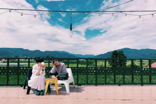 a bride and groom sitting in chairs on a patio at Puli Islet Inn in Puli